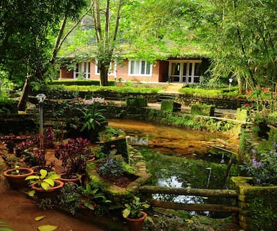 https://imgcld.yatra.com/ytimages/image/upload/t_hotel_yatra_city_desktop/v1442553311/Domestic Hotels/Hotels_Munnar/Ambady Falling Waters/Exterior.jpg